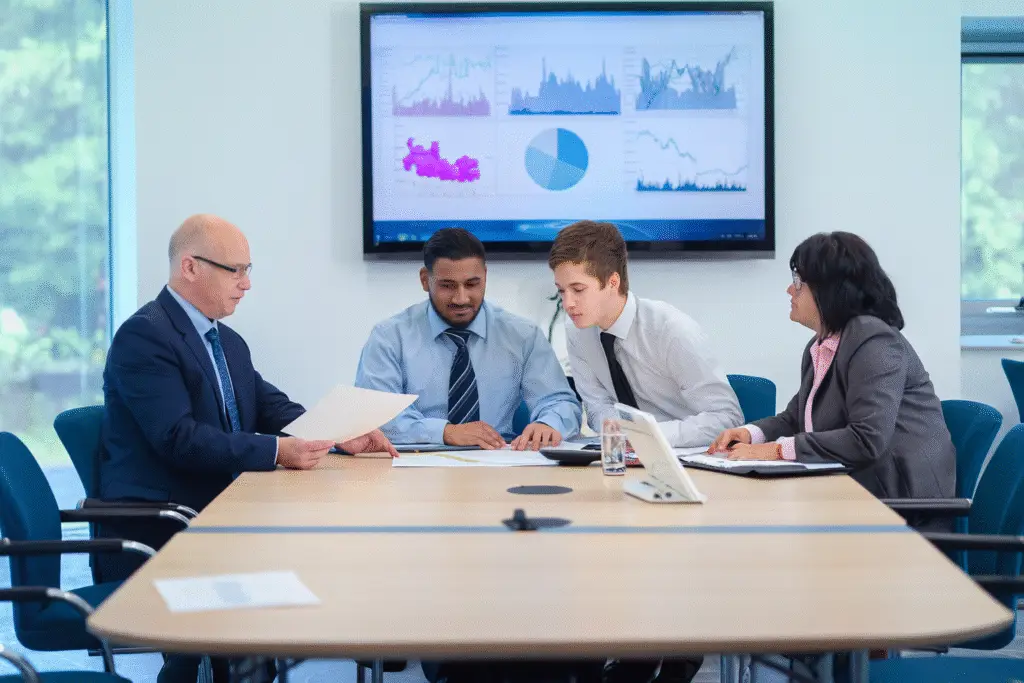 Business team reviewing hospital efficiency data with charts on screen